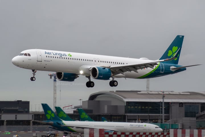 An Aer Lingus Airbus A321XLR aircraft landing at Dublin Airport, with another Aer Lingus plane visible in the background on the tarmac